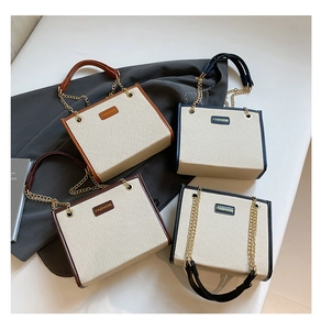 Détail de quatre sacs cabas colorés avec texture tissée, chaînes et étiquettes mode