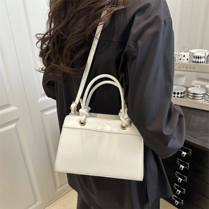 White minimalist crossbody bag with unique knot handle and fashion trend lettering print