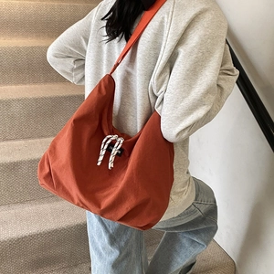Minimalist large orange canvas tote bag for women showing a retro commuter shoulder design