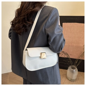 Détail du sac à bandoulière blanc minimaliste avec boucle carrée dorée et fermeture aimantée