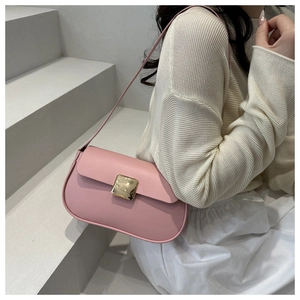 Detail of a light pink shoulder bag with gold square metal buckle on a minimal background