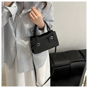 Détail du petit sac carré noir avec boucles argentées et bandoulière amovible