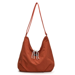Minimalist caramel nylon hobo tote bag with adjustable strap and fashion label