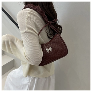 Detail of dark red woven leather bag featuring silver butterfly buckle and knotted strap