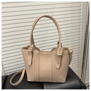 Detail view of pinkish PU leather handbag showing trapezoidal shape and metal hardware
