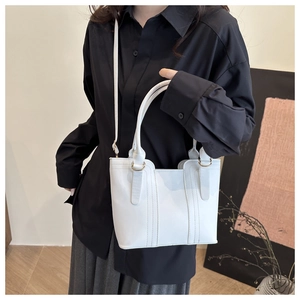 Macro detail of white leather handbag with golden metal buckles and elegant top handles