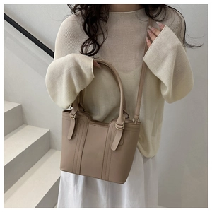 Detail of light khaki tote bag with gold ring handle and removable thin shoulder strap