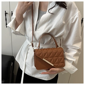 Close-up of caramel PU leather handbag featuring geometric quilting and gold metal trim