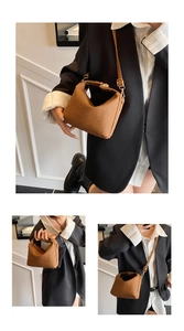 Detail of brown textured crossbody bag with woven pattern and gold metal zipper detail