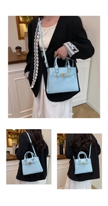 Detail of light blue crossbody bag featuring gold metal hardware and smooth finish