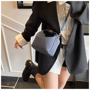 Detail van blauwe crossbodytas met geweven textuur, ritssluiting en schouderband