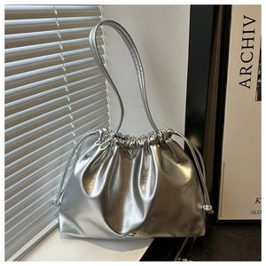 Dettaglio della borsa argento con coulisse in pelle lucida e decorazione a fiocco