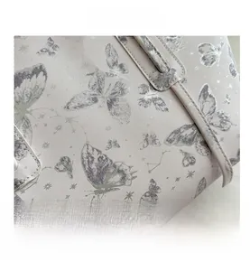 Close-up of durable twill fabric with grey butterfly and star patterns on a purple tote
