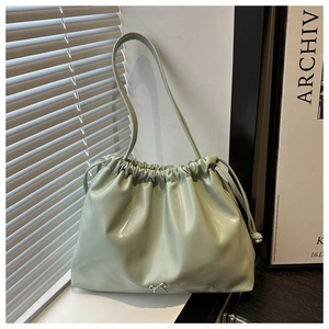 Dettaglio della borsa a secchiello verde menta con coulisse e fiocco in metallo argento