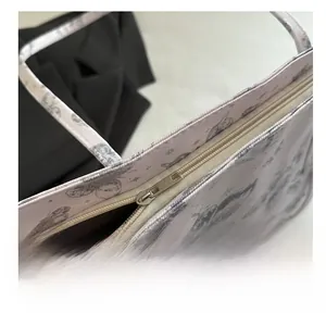 Detailed macro of smooth silver metal zipper on printed butterfly fabric tote bag