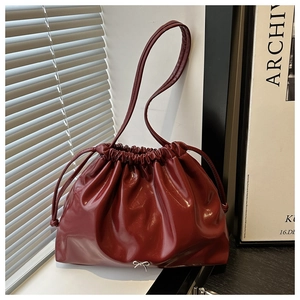 Dettaglio borsa bordeaux in pelle lucida con coulisse e fibbia a fiocco argento