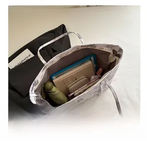 Detail view of large white butterfly tote bag showing spacious interior with daily essentials