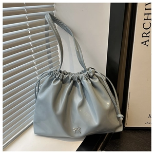 Dettaglio della borsa a pieghe azzurra con coulisse e ornamento a fiocco in argento