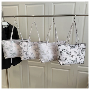 Close-up of printed tote bags showing four butterfly patterns and rectangular structure