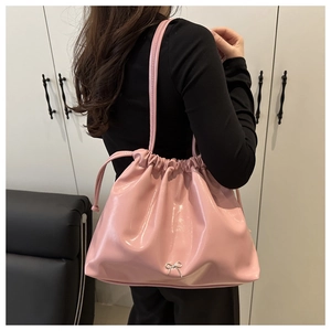 Détail du sac à bandoulière plissé en cuir verni rose avec nœud en métal argenté