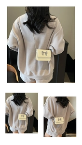 Detailed views of a mini cream chain bag with a silver metallic bow on a model