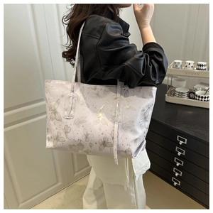 Detail of elegant butterfly print tote bag in cream finish with slim shoulder straps