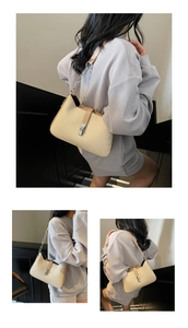Detail of light beige woven texture shoulder bag with silver metal twist lock and chain strap