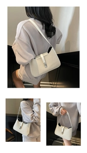 Detail view of off-white shoulder bag with twill texture and silver metallic buckle