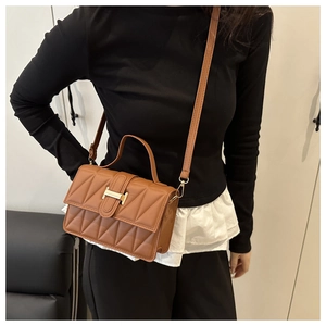 Détail du sac à main marron en cuir matelassé avec boucle en H et bandoulière