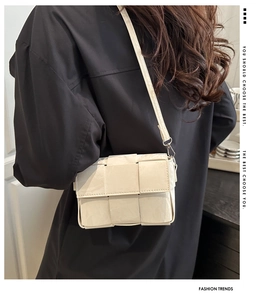 Detail of white woven leather crossbody bag showing intricate large grid weave pattern
