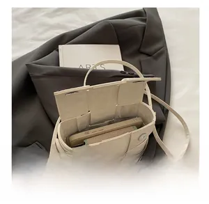 Interior view of cream woven crossbody bag showing capacity for phone and wallet