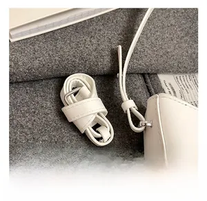 Close-up of adjustable white leather shoulder strap with polished silver metal buckle