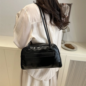 Glossy black bowling handbag with multiple pockets and double straps for daily commute