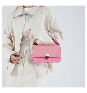 Détail de sac à rabat rose tissé avec un fermoir métallique rond doré élégant
