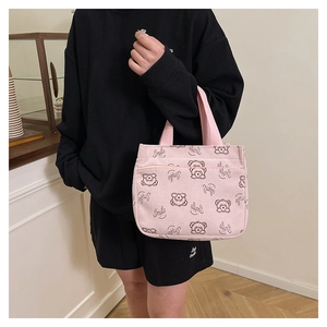 Détail du sac à main en velours côtelé rose avec motifs ours et inscription Smile