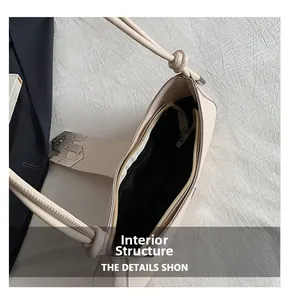 Detailed top view of beige underarm bag showing black lining and metal zipper closure