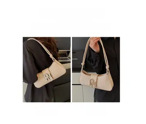 Detail of beige shoulder bag with silver buckle showing handheld and shoulder modes