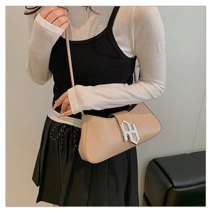 Detail of elegant beige crescent hobo bag with a modern silver geometric metal buckle