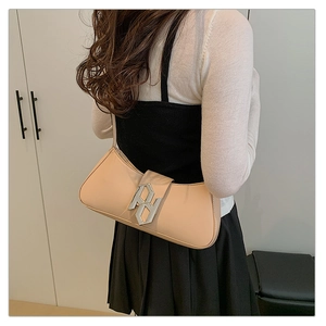 Detail of peach-beige smooth leather shoulder bag featuring a unique silver metallic buckle
