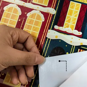 Peeling the self-adhesive backing of a hand-painted Christmas house wall sticker