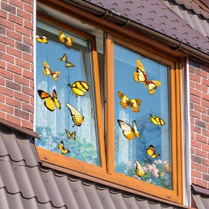 Detailed view of yellow butterfly window stickers on glass with a home brick background