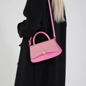 Pink crossbody saddle bag with textured fabric flap and gold hardware for women