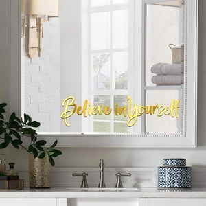 Gros plan du sticker miroir doré avec texte Believe in Yourself sur un mur de salle de bain