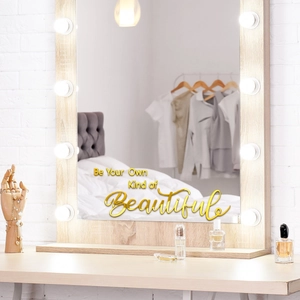 Détail du lettrage doré sur le miroir de maquillage Hollywood avec ampoules LED