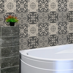 Detail of vintage mandala pattern wall stickers on a bathroom wall with a modern white bathtub