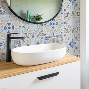 Modern bathroom detail with geometric tile backsplash and white ceramic vessel sink