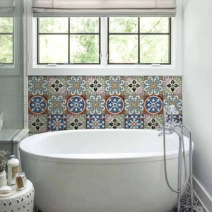 Detail of Mediterranean floral tile stickers on a bathroom wall above a white bathtub