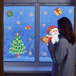 Christmas window decals with Santa Claus and snowflakes on glass in a cozy indoor scene