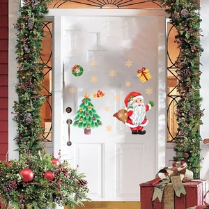Festive Christmas window decals featuring Santa, Xmas trees, and snowflakes on a white door