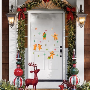 Close-up of cute Christmas gingerbread man and candy cane window decals on white door